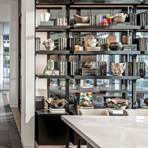 Artfully Curated Lounge Offering a Stylish Space to Relax, Work, or Connect Designer bookshelf filled with curated books and sculptures in a modern resident lounge at 2811 Maple
