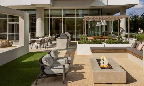 a firepit and chairs with a large window in the background